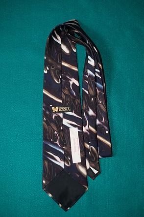 Brown patterned necktie on a green background