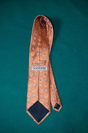 Orange patterned necktie on a dark green background