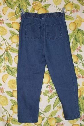 Dark blue jeans laid flat on a patterned floral background.