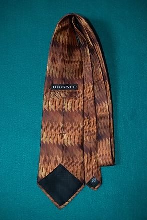 Brown patterned necktie on a teal background