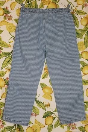 Blue-and-white striped pants laid flat on a floral lemon-patterned background