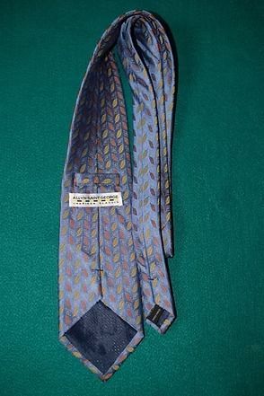 Patterned light gray tie on a green background