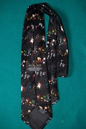 Black tie with colorful small figures on a teal background