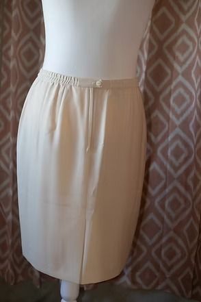 Cream-colored women’s suit jacket and skirt displayed on a mannequin