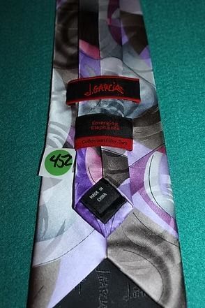 Purple and gray patterned necktie laid on a teal surface.