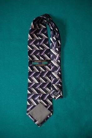Purple patterned necktie on a teal background