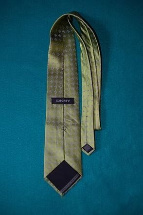 Light gold patterned necktie on a teal background