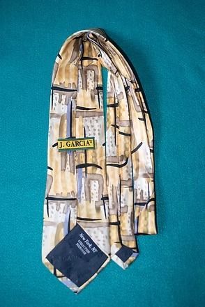 Patterned necktie with tan, blue, and black geometric design on a teal background