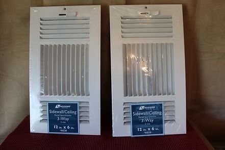 White 3-way sidewall ceiling vent register with adjustable louvers, in packaging on a wooden surface