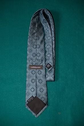 Gray patterned necktie on a green background