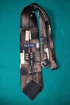 Black patterned necktie on a teal background