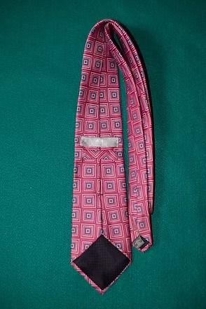 Pink patterned necktie on a green background