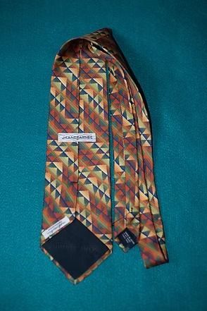 Multicolored patterned necktie on a teal background