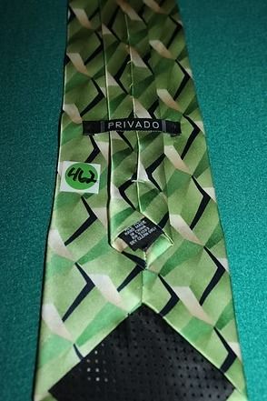 Green patterned necktie on a teal background
