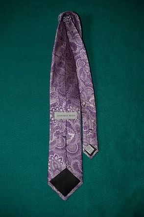 Purple paisley necktie on a green background