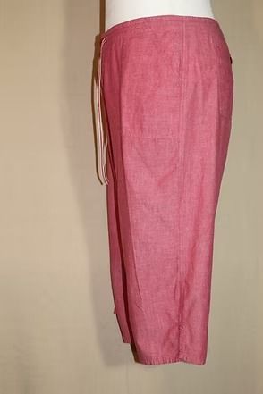 Pink ankle-length pants on a mannequin, side view against a beige background