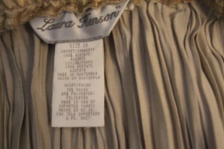 Beige patterned jacket with matching pleated skirt on a mannequin