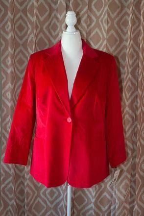 Red blazer jacket displayed on a mannequin against a patterned curtain backdrop