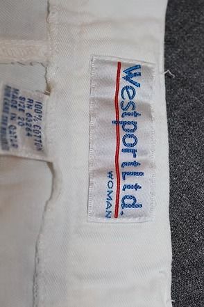 White shorts laid flat on a leafy patterned background.