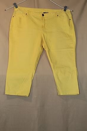 Yellow capri pants on a mannequin against a plain beige background.