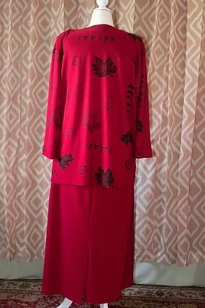 Red two-piece outfit on a mannequin against patterned curtains.