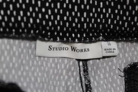 Black-and-white patterned pants laid flat on a lemon-print fabric background