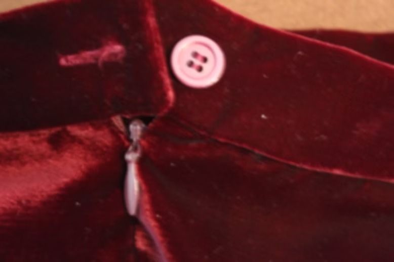Maroon sleeveless vest and matching skirt displayed against a light backdrop