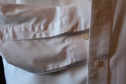 White button-up dress shirt with a collar and chest pocket on a hanger or person’s torso.