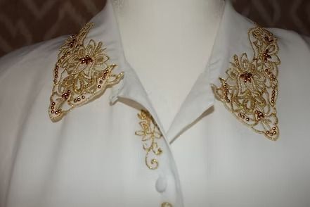 White blouse with ornate gold floral embroidery on the collar and buttons
