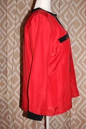 Red long-sleeve button-up blouse with black trim on a mannequin, front view