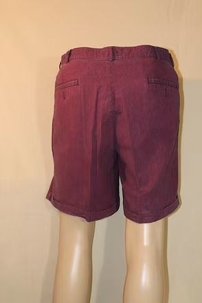 Maroon shorts on a mannequin against a plain beige background