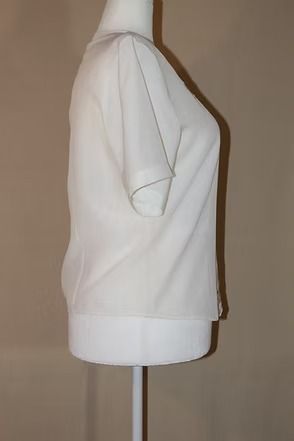 White short-sleeve blouse with lace detail on a mannequin