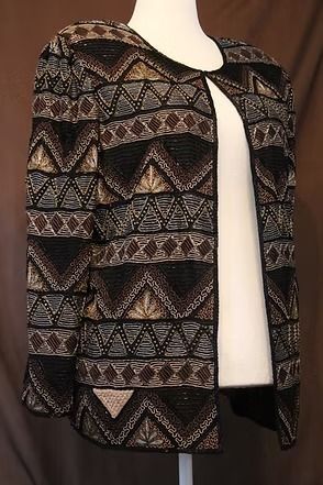 Patterned black-and-gold jacket over a white top on a mannequin