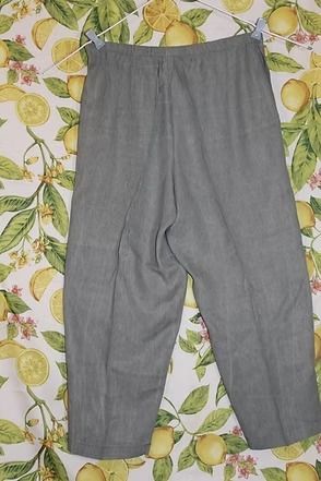 Gray pants laid flat on a lemon-patterned fabric background.