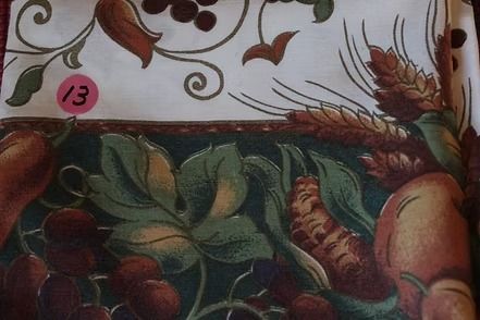 Decorative floral and fruit-patterned fabric border in green, red, and gold tones