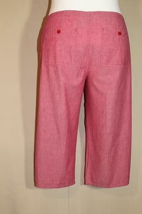 Pink ankle-length pants on a mannequin, side view against a beige background