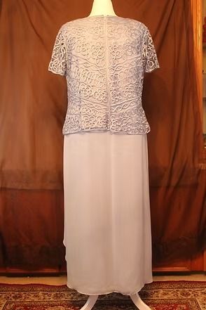 Mannequin wearing a patterned top and layered gray skirt against a brown backdrop