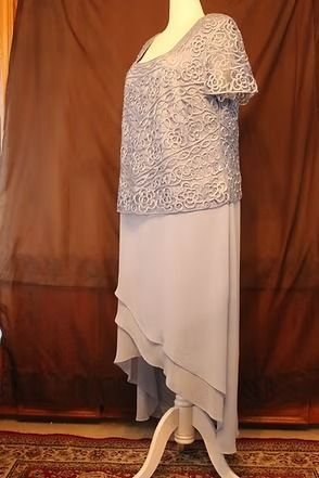 Mannequin wearing a patterned top and layered gray skirt against a brown backdrop