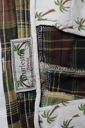 Plaid cargo shorts in red, green, and beige hanging against a plain wall