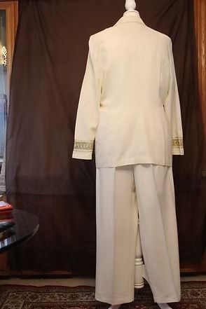White double-breasted suit with wide-legged trousers on a mannequin, displayed indoors