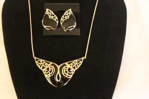 Gold butterfly jewelry set on black display bust, with matching earrings and necklace pendant.
