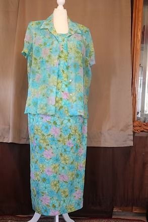 Floral blue-green button-up dress hanging against a tan backdrop