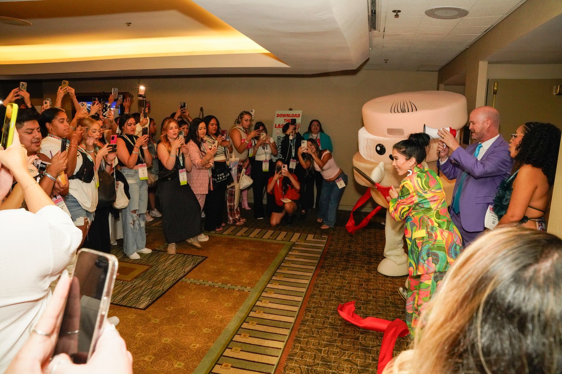 A group of people are taking pictures of a mascot in a room.