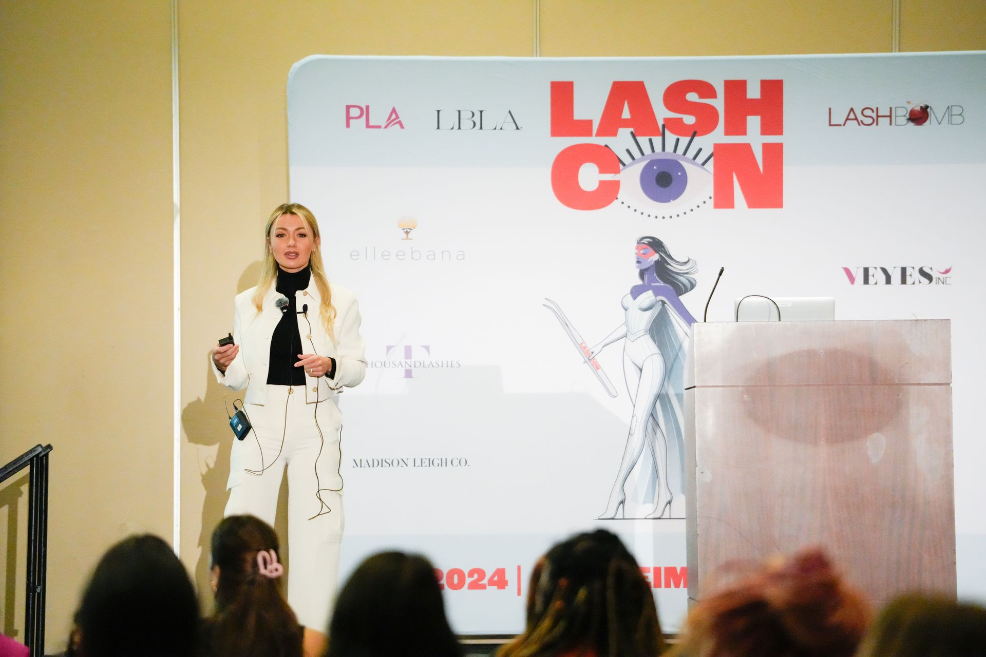 A woman is giving a presentation at a lash con