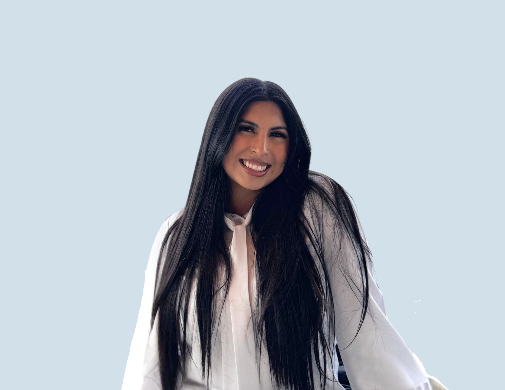 Smiling person with long black hair in a white blouse against a pale blue background