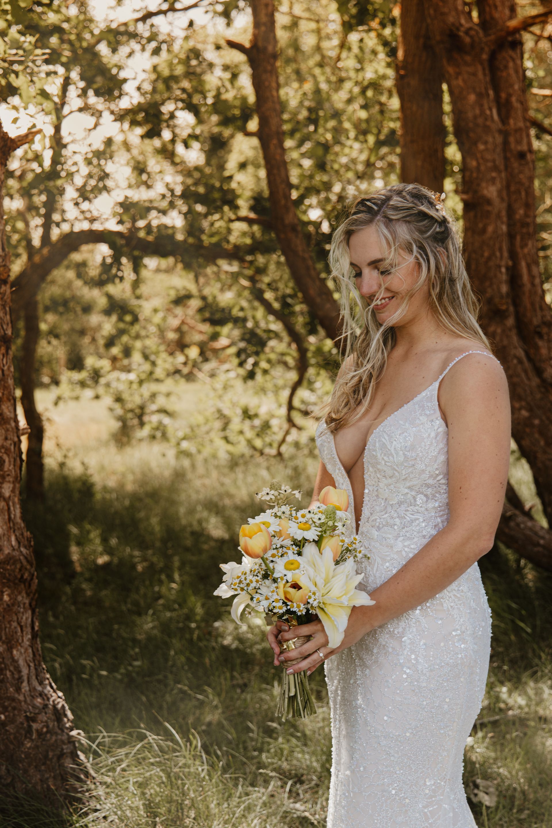 Twee mensen met boeken en witte bloemen tijdens een huwelijksceremonie in de buitenlucht.