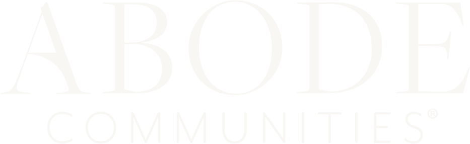 Faded white text reading “ABODE COMMUNITIES” on a light background