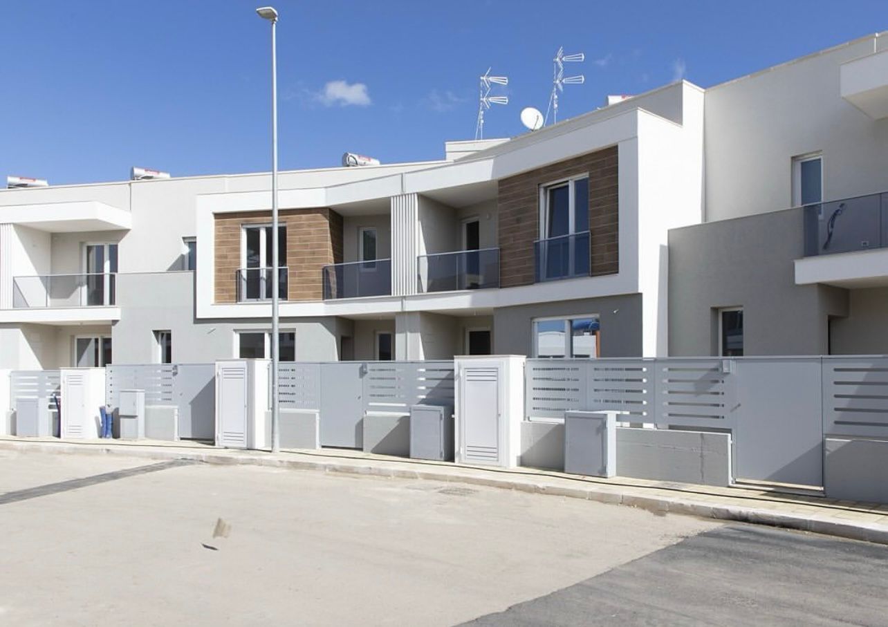 Fila di moderne case a schiera con dettagli bianchi e marroni, ciascuna con un balcone
