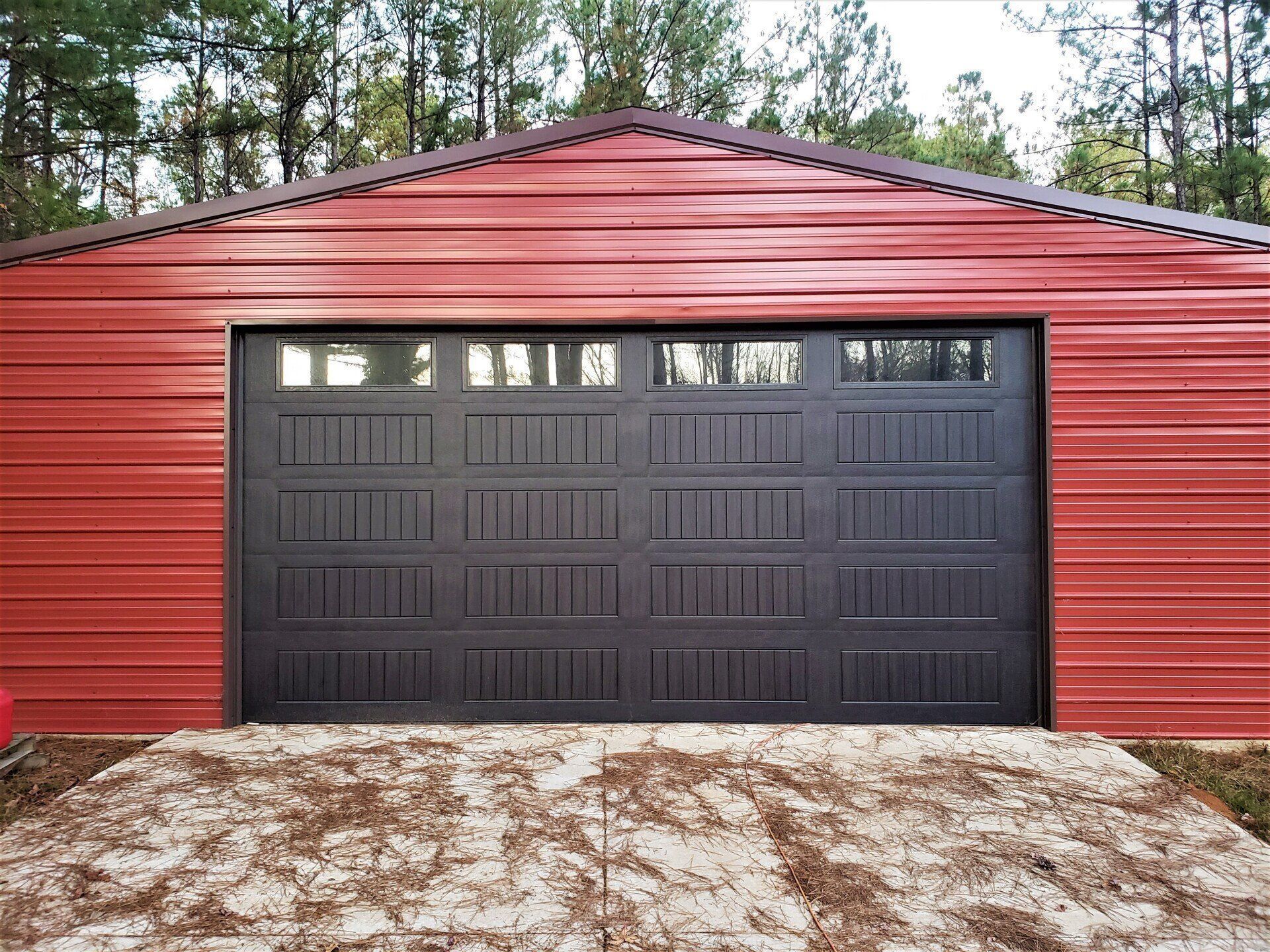 A large red garage with a black garage door