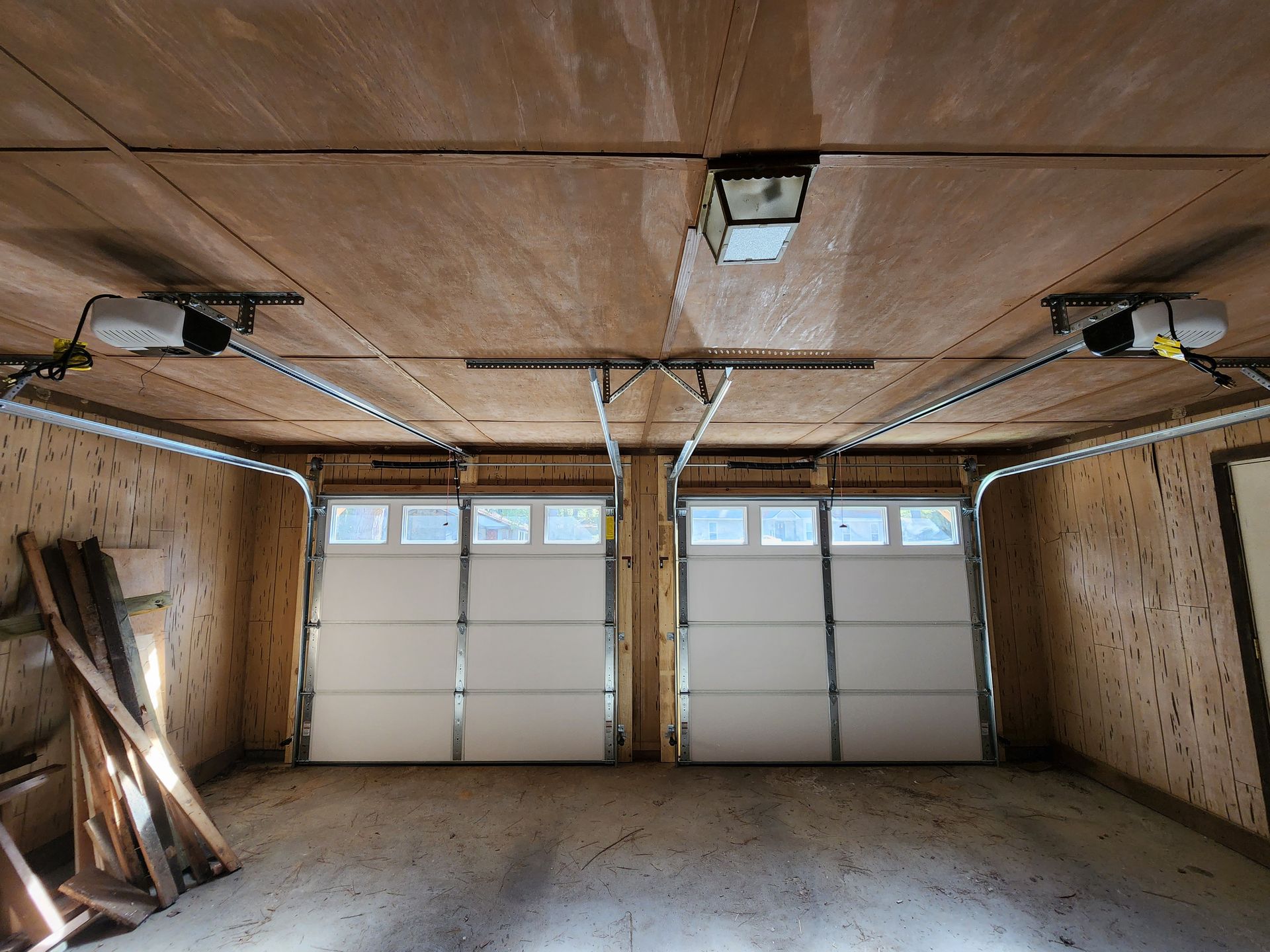 Vertical frame Interior of an empty garage with two large doors and small rectangular windows. Vertical frame Interior of an empty garage with two large doors and small rectangular windows.